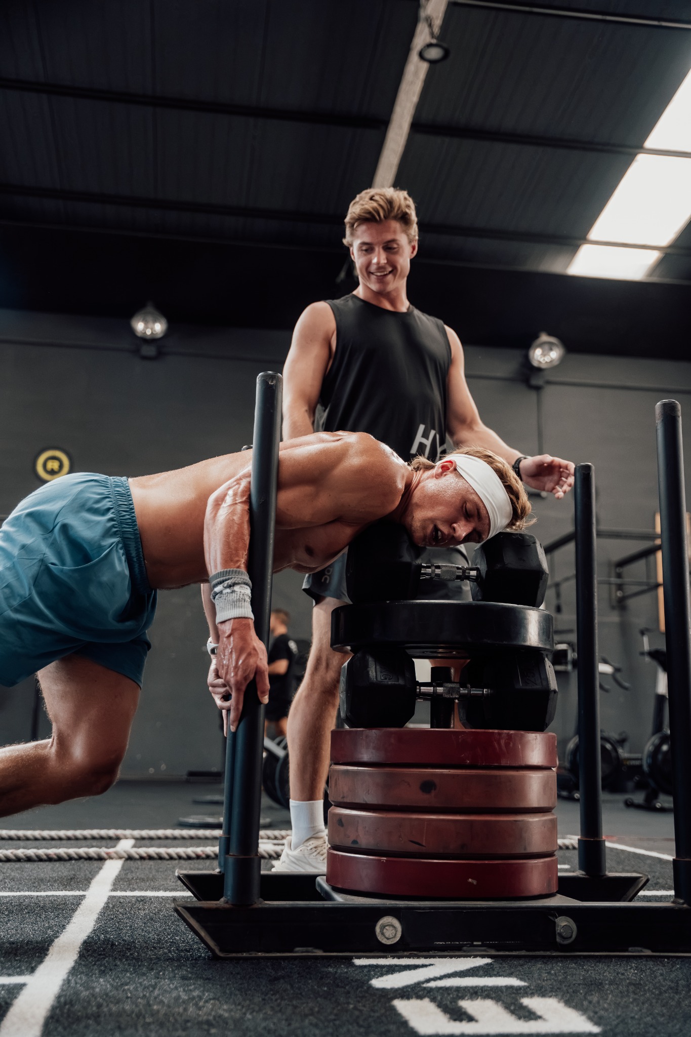 Coach supporting an athlete during a demanding sled training session